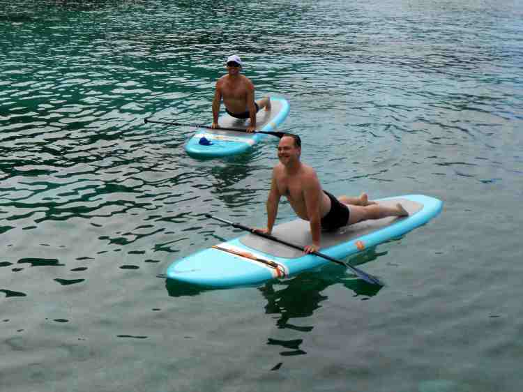 Dennis Hensley, doing yoga paddleboard in the Caribbean, reporting for ManAboutWorld gay travel magazine